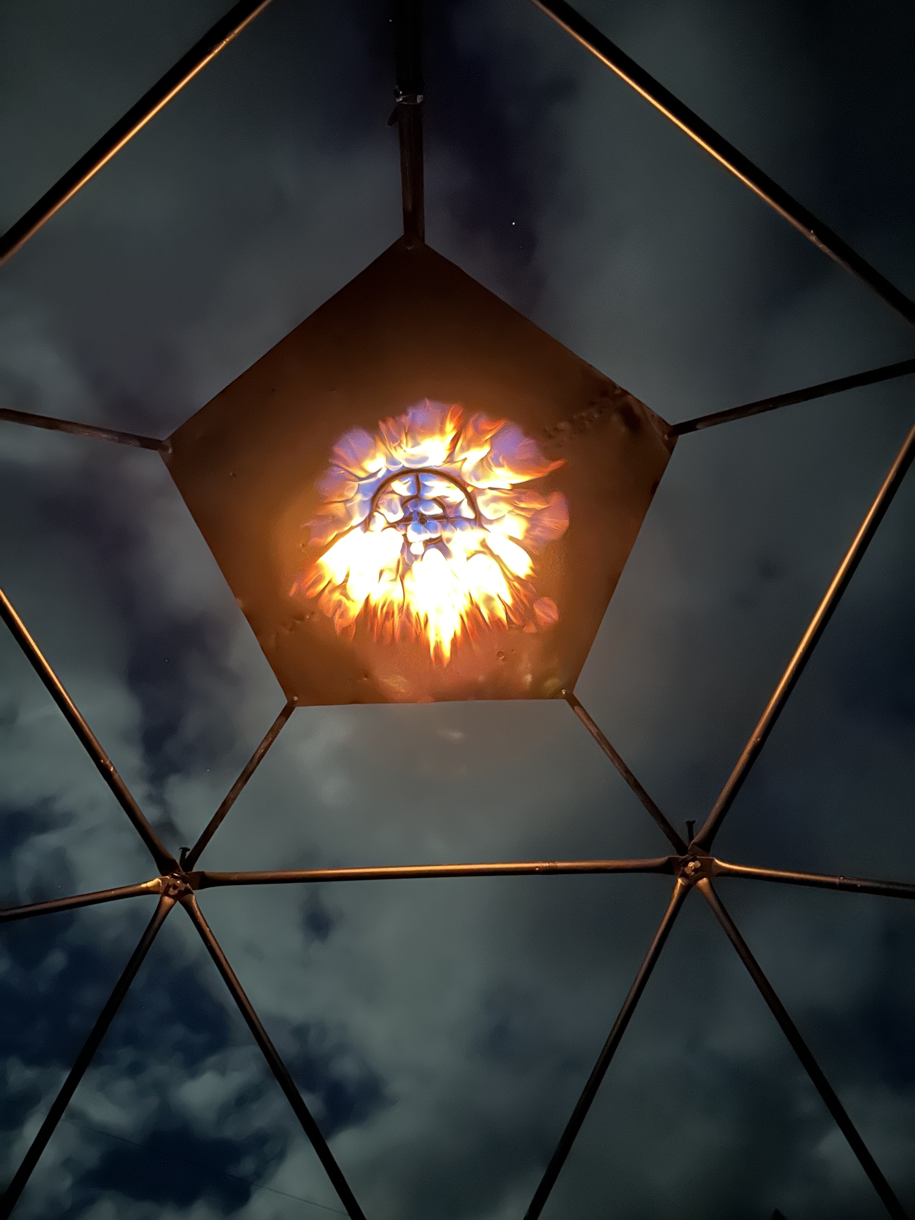 AGNIS geodesic dome lit by fire at night
